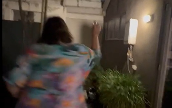 A still of a blurry Joanna throwing a glass against a wall